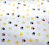 Baumwoll Stoff "Struppi" Pfotenabdrücke braun, schwarz, gelb, beige und grau auf weißem Hintergrund